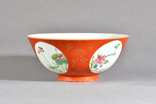 A Chinese coral  ground famille-rose medallion bowl, blue Qianlong seal mark but probably later, reserved with four panels enclosing lotus, peony, pru