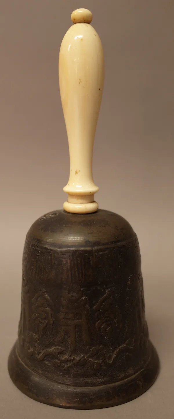 A Chinese bell metal handbell, probably 19th century, with archaistic relief decoration, turned ivory handle and clapper, 19cm. high.