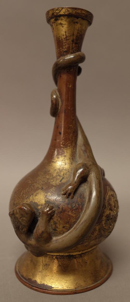 A Chinese parcel-gilt bronze bottle vase, possibly 18th century, decorated in relief with two barbed panels enclosing flowers against a ground engrave