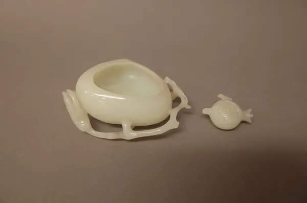 A Chinese white jade peach shaped brushwasher, carved with a branches of pomegranates and a finger citron, (a.f), 8.5cm. wide.