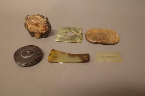 A Chinese jade scraper, possibly 1000-2000 BC, pierced at one end, the stone of celadon and brown tones, 6.5cm. high; also five other various jade car