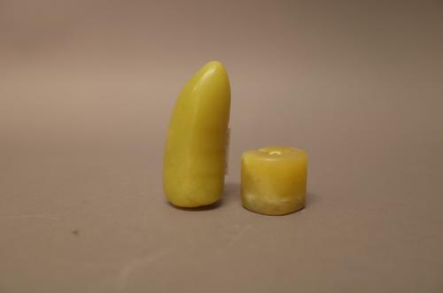 Two Chinese yellow jade beads, possibly Shang dynasty, one of split oval section, the other of bean form with ribbing to one side, 2cm. and 5cm. lengt