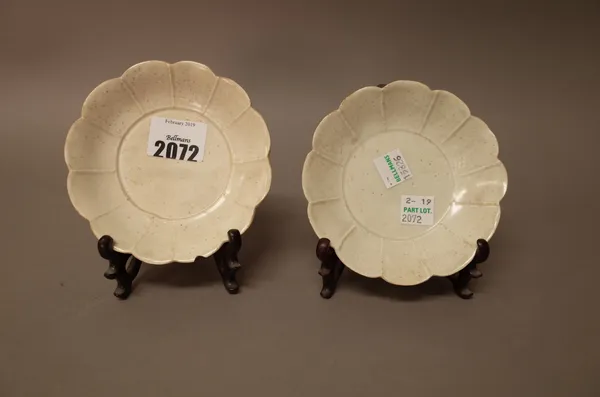 A pair of small Chinese qingbai porcelain dishes, Song dynasty, each with a panelled border and notched rim, 11cm. diameter, wood stands, (4).