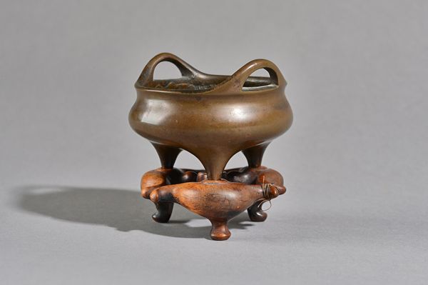 A small Chinese bronze two-handled tripod censer, possibly Ming dynasty, cast in the interior with two dragons around a four-character mark, two chara