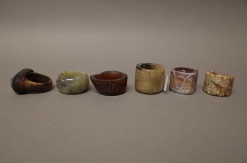 Four Chinese jade archer's rings, of various colour, two carved and two plain, tallest 3cm.; and two other rings, (6).