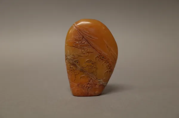 A Chinese brown soapstone seal, probably 18th century, of flattened boulder form, carved on one side with a figure in a boat fishing, beneath rows of
