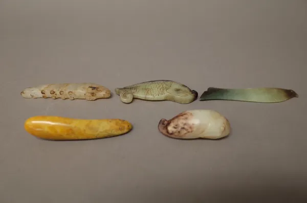 A group of Chinese jade carvings; comprising; three fish pendants; a fish carving and a carving of a caterpillar, various colours, 5cm. to 8.5cm. leng