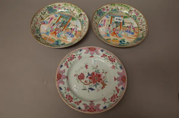 A pair of Canton famille-rose saucer dishes, 19th century, each painted with women at leisure in a fenced garden, beneath a border filled with flowers