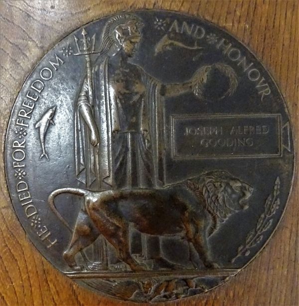 A First World War period bronze memorial plaque, detailed Joseph Albert Gooding, mounted to an oak display stand, J A Gooding Served as a private with