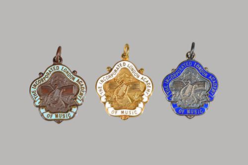 A 9ct gold and white enamelled medal detailed, The Incorporated London Academy of Music, gross weight 6.6 gms, a silver and dark blue enamelled medal