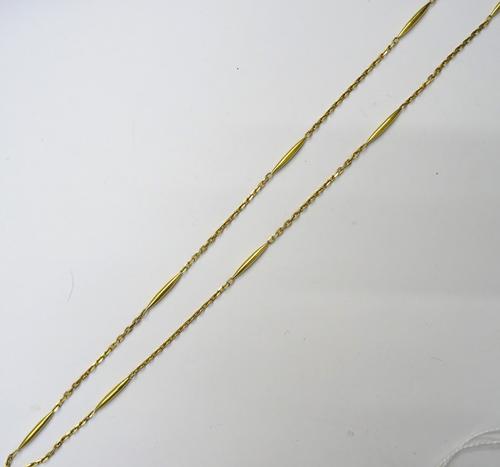 A gold necklace, in a tapered bar and faceted oval link design, detailed 750, on a boltring clasp detailed 750, fitted with a safety chain, weight 29.