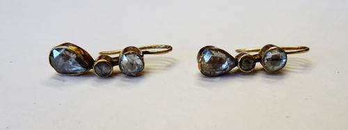 A pair of rose diamond set three stone pendant earrings, each mounted with the principal pear shaped rose diamond to the drop and with one larger and