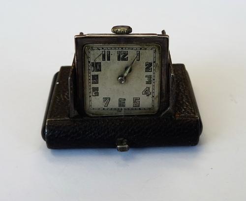 A silver and leather rectangular cased travelling watch, the square silvered dial with Arabic numerals, the case detailed 0,925.