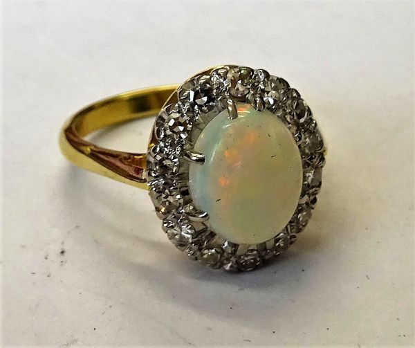 A gold, opal and diamond oval cluster ring, claw set with the oval opal in a surround of circular cut diamonds, detailed 18 CT, gross weight 5.7 gms,