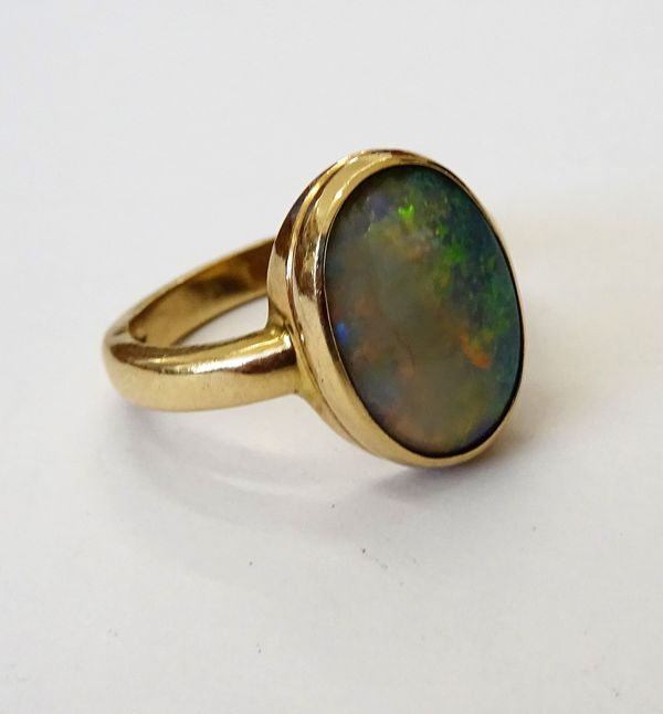 A 9ct gold ring, collet set with an oval opal (the opal chipped), ring size O and a half, gross weight 5 gms.