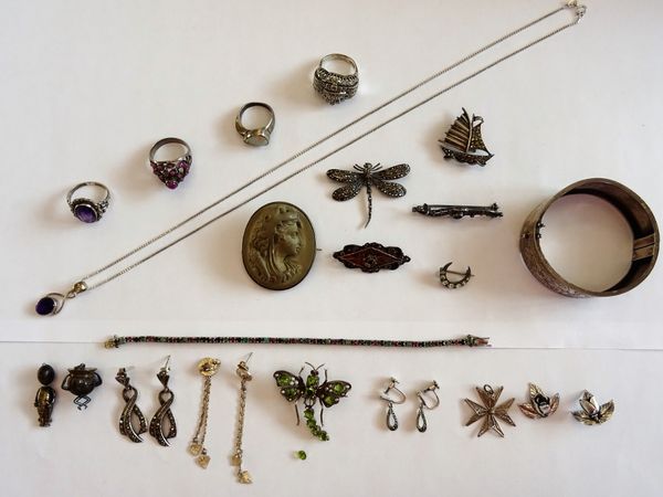 Mostly silver and silver mounted jewellery, comprising; an opal ring, a cabochon ruby ring, two further rings, four marcasite set brooches, a lava cam