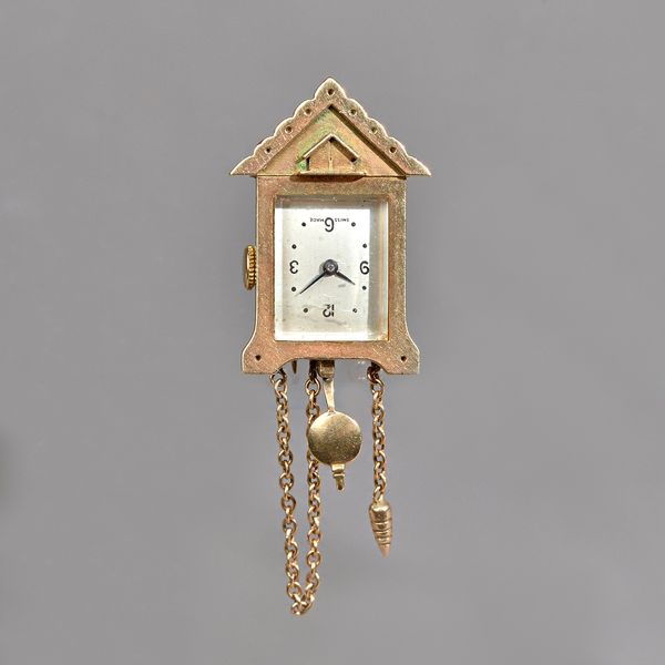 A 9ct gold watch clip brooch, designed as a miniature clock, the rectangular silvered dial with black Arabic and dot numerals and detailed Swiss Made,