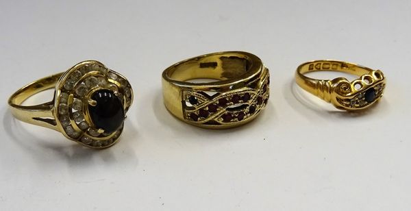 An 18ct gold, sapphire and diamond ring, in a scrolling design, Chester 1907, with a case, a 9ct gold and red gem set ring, in an entwined design and