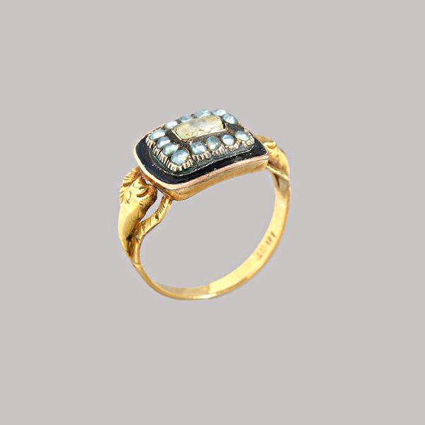 A Victorian gold, black enamelled and seed pearl set mourning ring, glazed with a central locket compartment, in a surround of seed pearls (one seed p