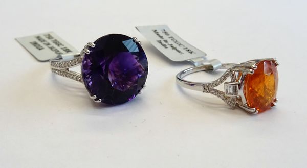 An 18ct white gold, amethyst and diamond ring, claw set with the circular cut amethyst between diamond set split V-shaped shoulders, detailed 18 K 750