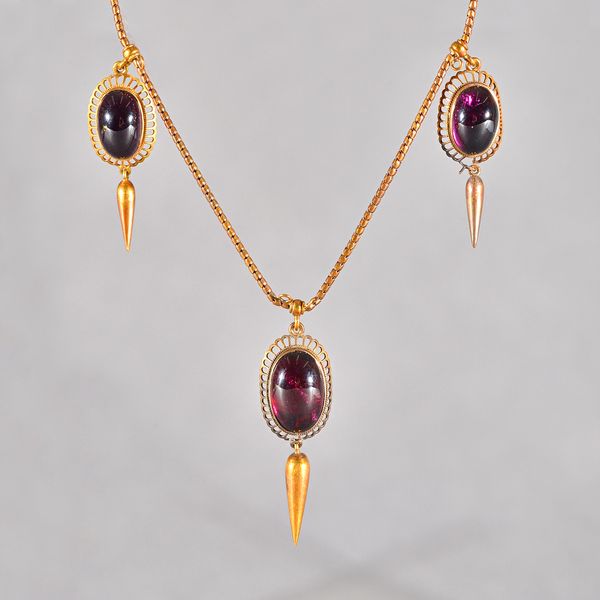 A Victorian gold and carbuncle garnet three stone pendant necklace, the front mounted with three oval carbuncle garnets, within pierced borders and wi