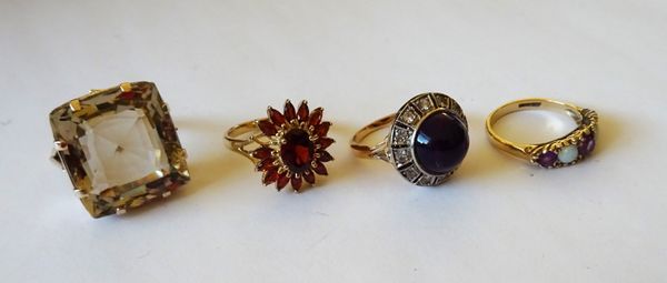 A 9ct gold and garnet set oval cluster ring (one garnet detached, but present), a cabochon amethyst and colourless gem set cluster ring, a 9ct gold, a