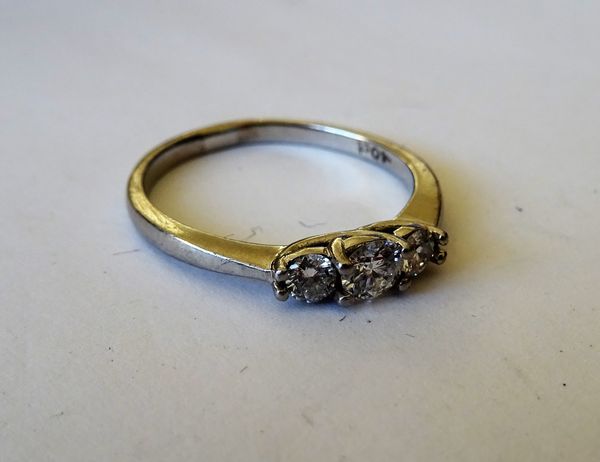 A platinum and diamond three stone ring, claw set with a row of circular cut diamonds and with the principal diamond mounted at the centre, ring size