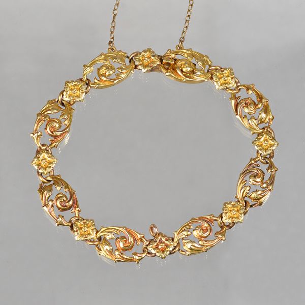 A European gold bracelet, designed as a series of scroll pierced, open work oval links, alternating with stylized flower heads on a snap clasp, fitted