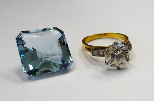 A gold ring, claw set with a circular cut colourless gem, between colourless gem set two stone shoulders, detailed 18 CT, ring size M, with a case and