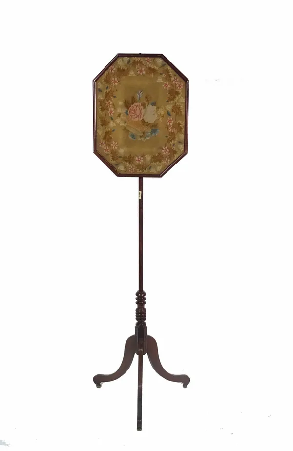 A 19th century mahogany pole screen with floral needlework pommel on three outswept supports, 148cm high.