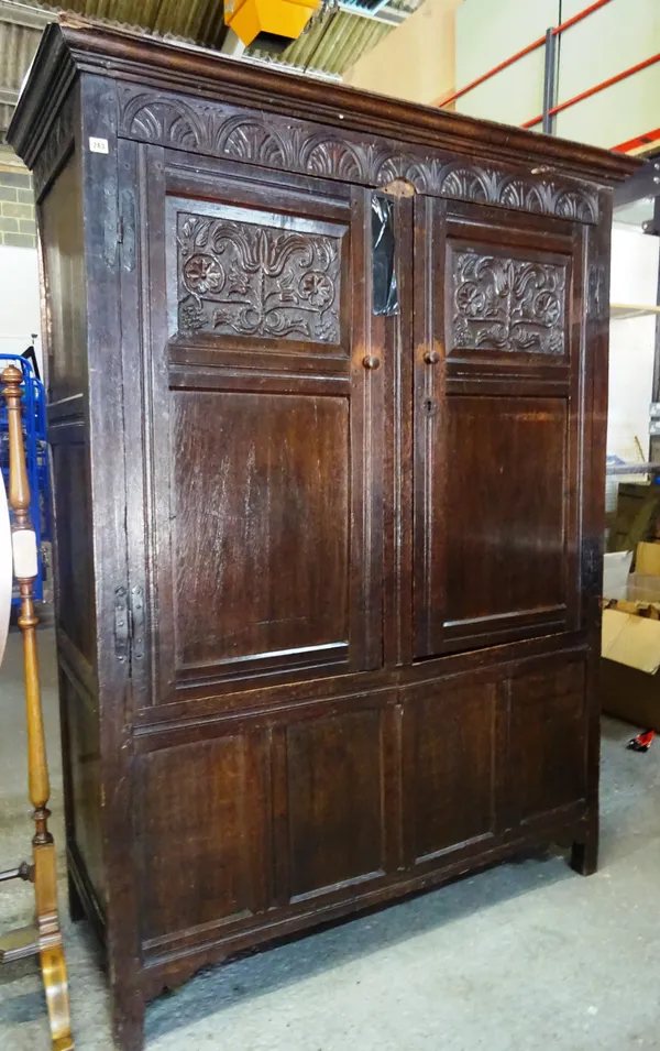 An 18th century and later oak two door cupboard with carved inset panels, 150cm wide x 195cm high.