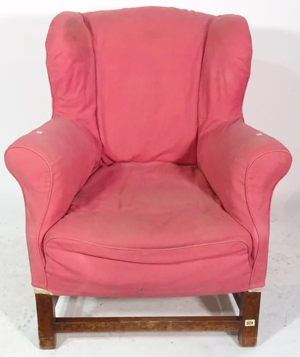 A 20th century pink upholstered wing armchair with cabriole supports and perimeter stretcher.
