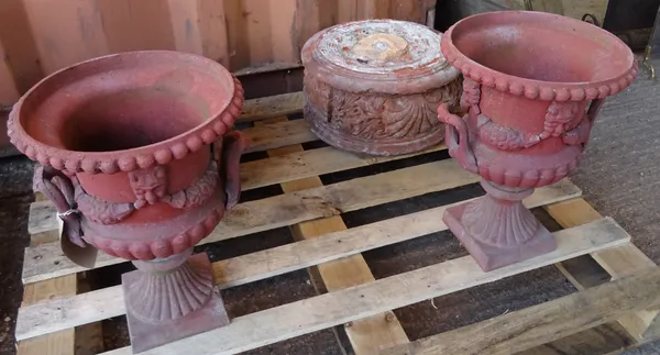 Garden statuary, comprising; a pair of terracotta circular plinths, 42cm diameter x 23cm high and a pair of red painted cast iron urns, 47cm high, (4)