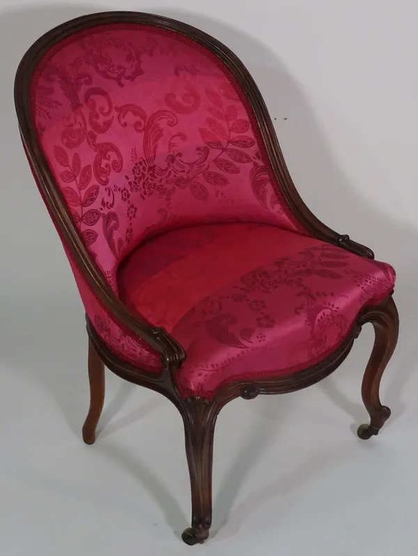 A 19th century French walnut framed pink upholstered nursing chair on cabriole supports, 77cm high.