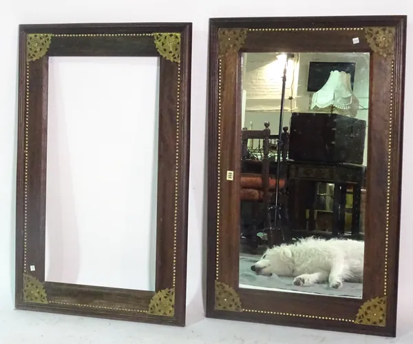 A pair of African hardwood and brass studded rectangular wall mirrors, one lacking mirror plate, 105cm wide x 88cm high (2).