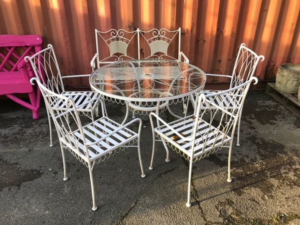 A set of four 20th century white painted metal garden chairs and a similar two seater bench, (5).