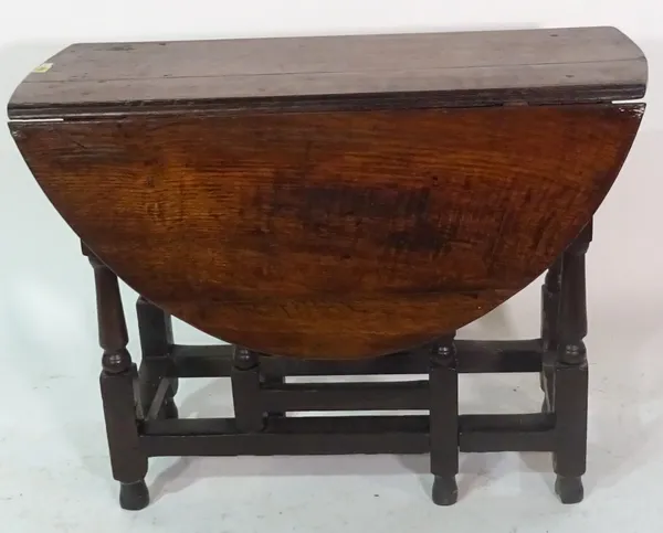 A 17th century and later oak drop flap table on turned supports, 94cm wide x 70cm high.