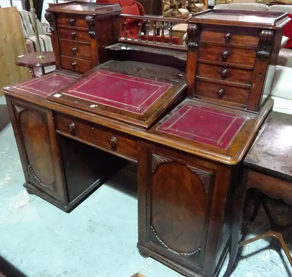 A Victorian mahogany Dickens type desk, with double four drawer Wellington chest superstructure, sloping writing surface and nine drawers about the kn