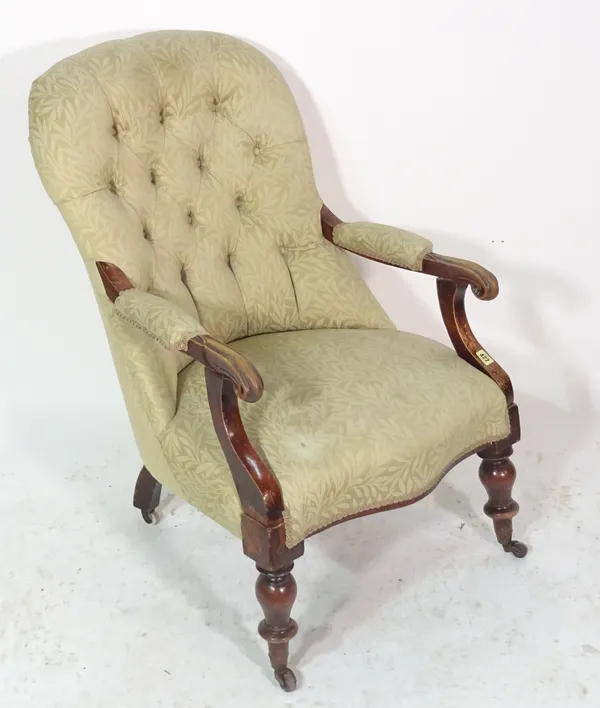 A Victorian mahogany framed open armchair with button back upholstery.