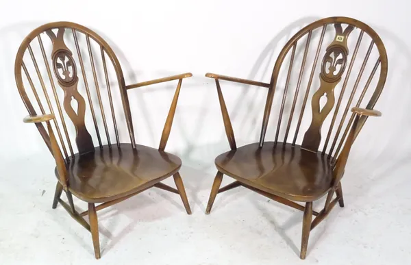 Ercol; a pair of ash and elm low stickback open armchairs, (2).