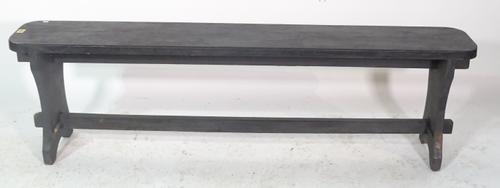 An early 20th century black painted bench on trestle supports, 150cm wide x 41cm high.