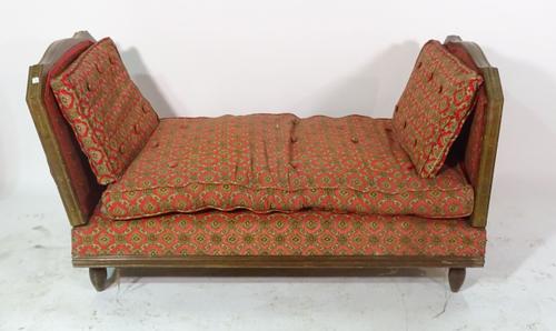 An early 20th century French beech day bed on tapering supports.