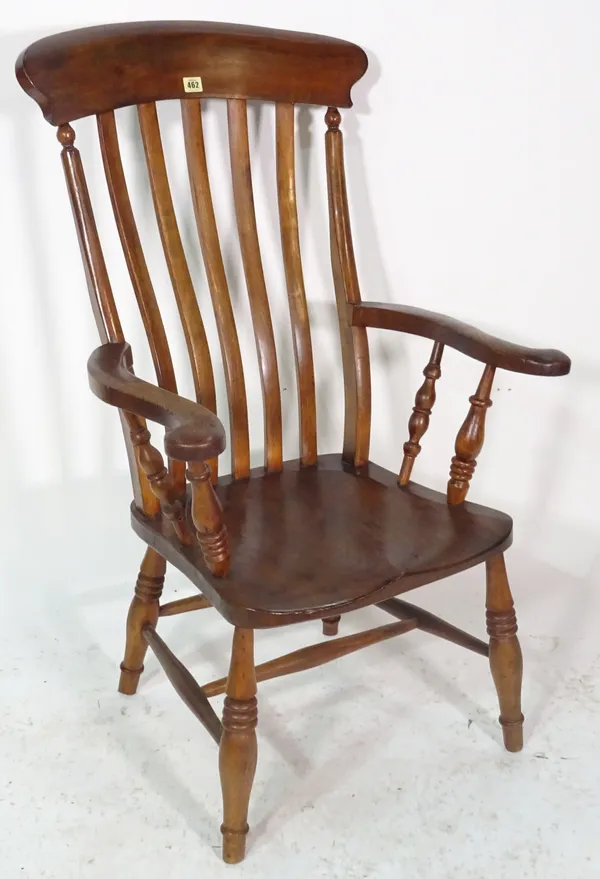 An early 20th century ash and elm open armchair on ring turned tapering supports.