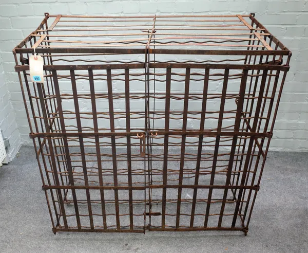 A wrought iron wine rack, 19th century, wall mounted with lockable twin hinged doors with space for over 200 bottles. 108cm high x 110cm wide x 58cm d