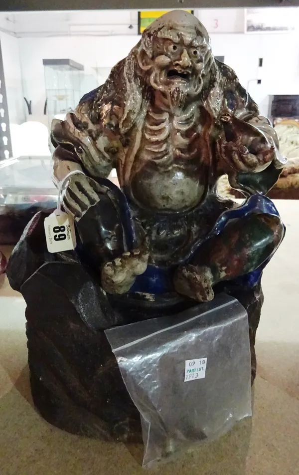 A Japanese Satsuma figure of Gama Sennin, Meiji period, seated with a toad in his left hand, raised on a separate rockwork base, (a.f), 33cm.high