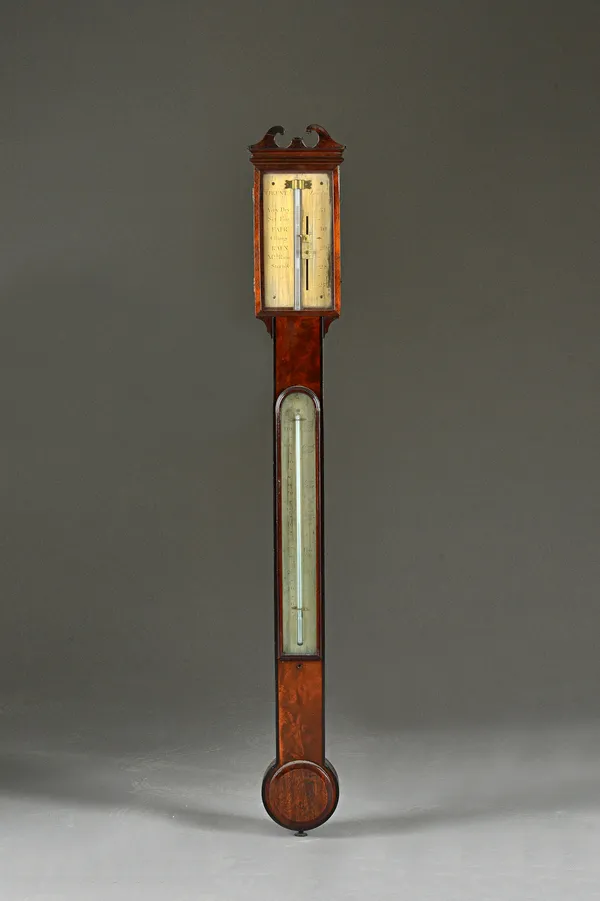 An early 19th century mahogany cased stick barometer by T. BLUNT, LONDON, with broken arch pediment, gilded dial, visible mercury tube over a thermome