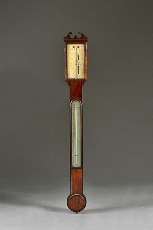 An early 19th century mahogany cased stick barometer by T. BLUNT, LONDON, with broken arch pediment, gilded dial, visible mercury tube over a thermome