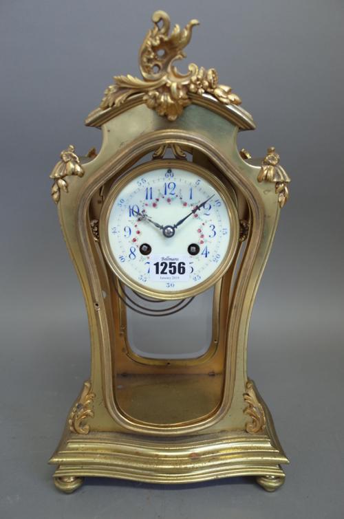 A French four glass mantel clock of waisted form, late 19th century, with foliate painted enamel dial and two train movement, the gilt metal pendulum