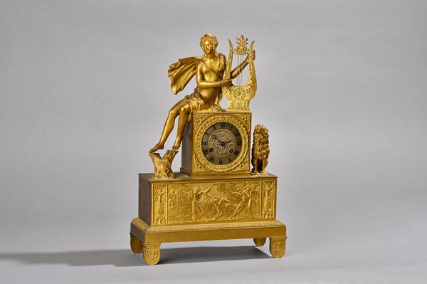 A French Empire style gilt metal figural mantel clock, 19th century, the Classical female figure playing a harp with lion beneath, the drum case enclo