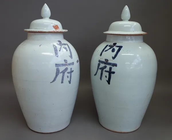 A pair of modern Chinese pottery vases and covers decorated with blue script against a white ground, 53cm high. (2)